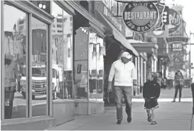  ?? NIKKI BOERTMAN/THE COMMERCIAL APPEAL ?? Basketball fan Jay Gentry, of Little Rock, Ark., visits Beale Street with his son, Gavin Gentry, 8, as they wait to check into their hotel ahead of the NCAA tournament’s regional games in Memphis recently. The pair are Arkansas fans, but got tickets to...