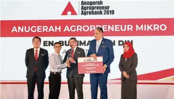 ??  ?? Well done: Salahuddin presenting prizes to one of the winners of the Agrobank Agropreneu­r Awards 2019 in Kuala Lumpur.