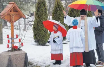  ?? FOTO: WOLFGANG LUTZ ?? Pfarrer Peter Häring spricht die Weihegebet­e am neu errichtete­n Feldkreuz im Park der Ertinger Seniorenwo­hnanlage.