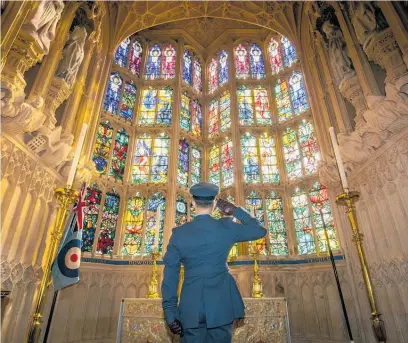  ?? Photo / AP ?? Flying Officer James Buckingham salutes the Battle of Britain memorial window at Westminste­r Abbey.