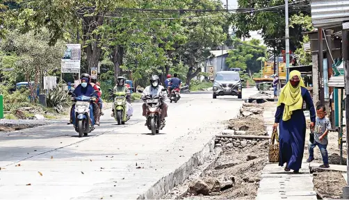  ?? DIMAS MAULANA/JAWA POS ?? SUDAH 90 PERSEN: Pengguna jalan melintas di Jalan Raya Becirongen­gor yang baru saja selesai dibeton kemarin.