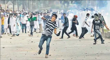  ?? WASEEM ANDRABI/HT ?? Protesters hurling stones at police and paramilita­ry personnel in Srinagar on Saturday.