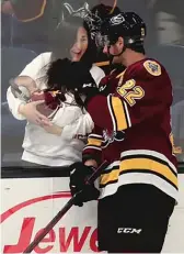  ?? CHICAGO WOLVES ?? Andrew Poturalski skates against the Rockford IceHogs (left) and greets his wife, Haley, and their son, Morrison John, during a game.