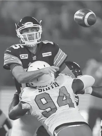  ?? STEVE RUSSELL/TORONTO STAR ?? Argos QB Ricky Ray gets the pass off in the nick of time as he is hammered by Lions’ Khreem Smith on Friday.