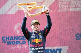  ??  ?? Red Bull driver Max Verstappen of the Netherland­s holds up his award on the podium after winning the Austrian Formula One Grand Prix at the Red Bull Ring racetrack in Spielberg, Austria, on July 4. (AP)