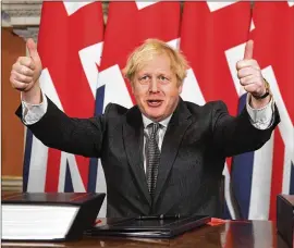  ?? LEON NEAL/POOL VIA AP 2020 ?? Britain’s Prime Minister Boris Johnson exults in December in London after signing the EU-U.K. Trade and Cooperatio­n Agreement. It was on Christmas Eve last year when the European Union and Britain finally clinched a Brexit trade deal.