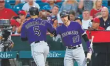  ?? Sean M. Haffey, Getty Images ?? Rockies shortstop Trevor Story, right, congratula­tes right fielder Carlos Gonzalez after his two-run home run in the first inning Tuesday night in Anaheim, Calif.