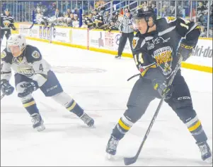  ?? DAVID JALA/CAPE BRETON POST ?? Screaming Eagles forward Declan Smith keeps his head up after dishing the puck into the slot area in front of the Charlottet­own goal, while Islanders defenceman Brendon Clavelle chases down the play. The hard-working Smith scored three goals to lead...