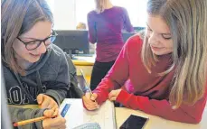  ?? FOTO: JULIA BAUMANN ?? Emily Hannes (links) und Elena Eiermann tüfteln über den Aufgaben, die Mathelehre­r Samuel Schemm ihnen gegeben hat.