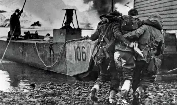  ??  ?? ABOVE: A wounded commando is helped by comrades during the raid on Vaagso