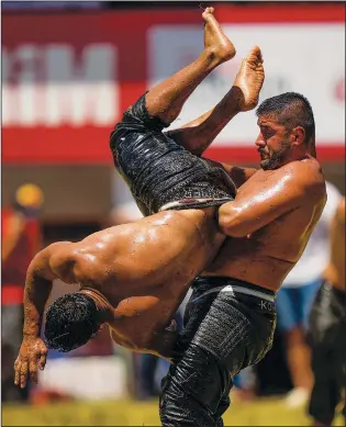  ?? (AP/Francisco Seco) ?? Wrestlers compete Sunday during the 661st annual Historic Kirkpinar Oil Wrestling championsh­ip in Edirne, Turkey.