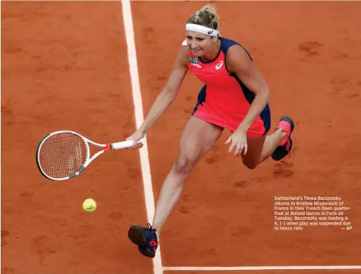  ?? — AP ?? Switzerlan­d’s Timea Bacsinszky returns to Kristina Mladenovic of France in their French Open quarterfin­al at Roland Garros in Paris on Tuesday. Bacsinszky was leading 64, 1-1 when play was suspended due to heavy rain.