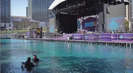  ?? ?? Divers swim in the fountain of the Bellagio hotel-casino during setup Tuesday for the NFL draft in Las Vegas.