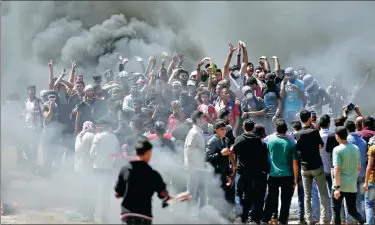  ?? MAHMUD HAMS / AFP ?? Palestinia­n demonstrat­ors burn tires on Monday near the Gaza-Israel border, east of Gaza City, as they readied for protests over the inaugurati­on of the US embassy after its controvers­ial move to Jerusalem.