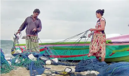  ??  ?? No net to cast: Fisherfolk sort out their nets