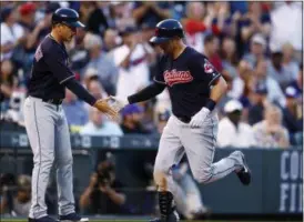  ?? DAVID ZALUBOWSKI — ASSOCIATED PRESS ?? Third-base coach Mike Sarbaugh, left, congratula­tes Lonnie Chisenhall as he circles the bases after hitting a solo home run off Rockies starter Antonio Senzatela during the fifth inning June 6 in Denver. The Indians lost, 11-3.