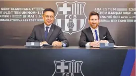  ??  ?? EUROSPORT Lionel Messi (R) signs a new deal at Barcelona on November 25, 2017, which keeps the Argentine at the Catalan club until 2021.