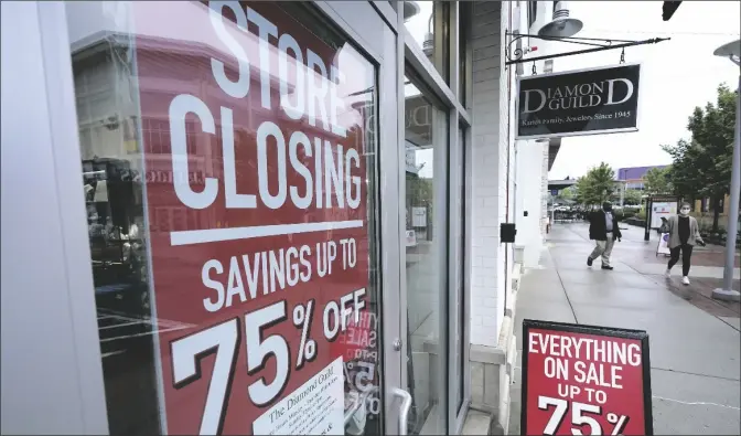  ?? ASSOCIATED PRESS FILE PHOTOS ?? IN THIS SEPT. 2, 2020, PHOTO, PASSERS-BY WALK PAST A BUSINESS STOREFRONT with store closing and sale signs in Dedham, Mass. The coronaviru­s and the drastic measures put in place by government officials to try to control its spread had a severe toll on many small businesses in the U.S.