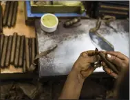  ?? (Bloomberg News via WPNS/Dennis M. Rivera Pichardo) ?? A worker rolls tobacco into a cigar at the Quesada Cigars facility in Santiago de los Caballeros, Dominican Republic.