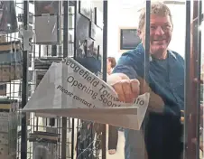  ?? Photo: Chaise Reeler ?? Local resident and tourism enthusiast,, Jurgens van der Walt, showing his excitement at finally removing the “opening soon” sign from the new Sedgefield Tourism Informatio­n Arts &amp; Crafts office window during its officially opening on Thursday, 13 September.