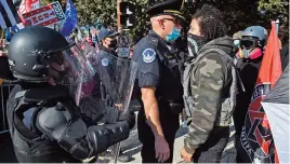  ?? (AFP) ?? This file photo shows police officials standing guard between counter-protesters and supporters of US President Donald Trump during a rally in Washington, DC