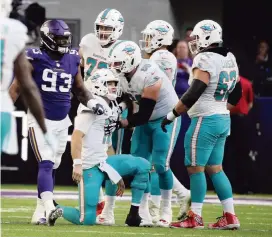  ?? CHARLES TRAINOR JR. ctrainor@miamiheral­d.com ?? Dolphins QB Ryan Tannehill is helped up by his offensive line after being sacked in the third quarter against the Vikings on Sunday. Tannehil was sacked a team-record nine times.