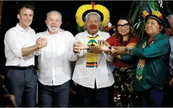  ?? — AFP photo ?? (From left) Macron, Lula, Metuktire, Brazilian First Lady Rosangela Janja Da Silva, and Brazilian Yanomami shaman and spokespers­on for Yanomami people Davi Kopenawa Yanomami gesture during a meeting at Combu Island, in front of Belem, state of Para, Brazil.