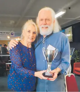  ??  ?? MAH JONG: Roger Kennerley who was the winner receiving his cup from Maree Schiphorst.