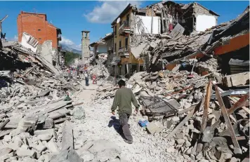  ?? — Reuters ?? A man walks amidst rubble following an earthquake in Pescara del Tronto, central Italy on Thursday.