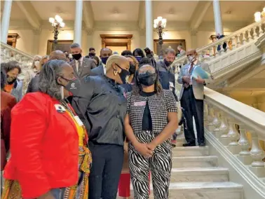  ?? AP PHOTO/JEFF AMY ?? Georgia House Democrats whisper to Democratic Rep. Park Cannon, right, on Friday in Atlanta. Cannon was preparing to speak to reporters after lawmakers concluded a two-hour sit-in at the state capitol sparked by opposition to Republican proposals that would restrict voting.