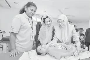  ?? — Gambar Bernama ?? MESRA: Wan Azizah (kanan) diiringi Elahe (dua kanan) beramah mesra bersama adik Abdul Rab Afzali, 7, selepas merasmikan Tasputra PERKIM di Jalan Lingkungan U-Thant semalam.