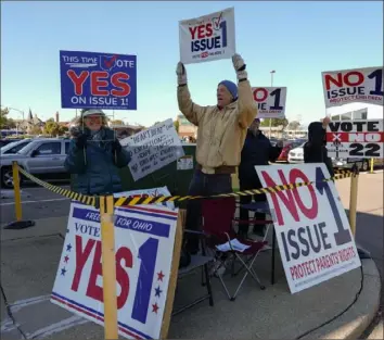  ?? Carolyn Kaster/ Associated Press ?? Demonstrat­ors show signs for Issue 1, guaranteei­ng reproducti­ve rights, in a parking lot as voters arrive for early in- person balloting in Cincinnati last year.
