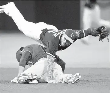  ?? Jason O. Watson Getty Images ?? THE ANGELS’ Grant Green is tagged out by Oakland’s Brett Lawrie while attempting to steal second base.