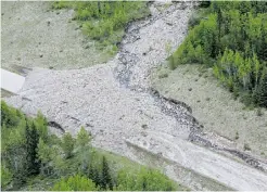  ??  ?? Debris from flooding covers a section of Highway 40 in Kananaskis Country.