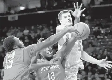  ?? PATRICK SEMANSKY/ASSOCIATED PRESS PHOTOS ?? Maryland forward Michal Cekovsky, right, reaches for a rebound over Stony Brook guard Akwasi Yeboah, left, and forward Tyrell Sturdivant in the first half of Tuesday night’s game. Cekovsky finished with 11 points, seven in the second half.