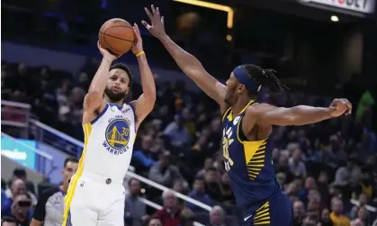  ?? Photograph: Michael Conroy/AP ?? Warriors guard Stephen Curry shoots over Pacers center Myles Turner during the first half of Wednesday’s game.