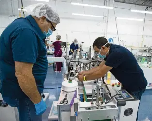  ?? DAVID SANTIAGO dsantiago@miamiheral­d.com ?? DemeTech employees work on the assembly line at the company’s Doral facility.