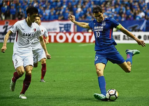  ?? — AFP ?? Eyes on the
ball: Shanghai Shenhua midfielder Giovanni Moreno (right) in action against Kashima Antlers defender Naomichi Ueda during the AFC Champions League match in Shanghai on Tuesday.
