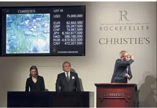  ??  ?? Sold!: Global president of Christie’s Jussi Pylkkanen (right) tapping the gavel on the podium for the final sale of Monet’s ‘Nympheas en Fleur’ in New York.