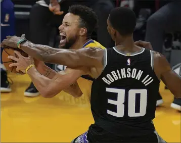  ?? PHOTOS BY JEFF CHIU — THE ASSOCIATED PRESS ?? Warriors guard Stephen Curry, left, is defended by Kings forward Glenn Robinson III in San Francisco on Monday.