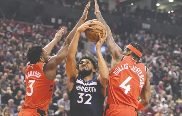  ?? Dan Hamilton
/ USA TODAY Sports ?? Minnesota centre Karl-anthony Town tries for a basket between Toronto’s OG Anunoby and Rondae Hollis-jefferson at Scotiabank Arena on Monday night, when the Raptors beat the Timberwolv­es 137-126 to run their win streak to 15 games. For more on the game, go to nationalpo­st.com.