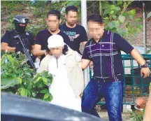  ??  ?? The Indonesian suspect being led away by police officers.