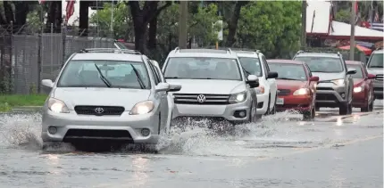  ?? JOE CAVARETTA/AP ?? Drivers try to navigate a flooded street Sunday in Fort Lauderdale. South Florida can expect more rain.