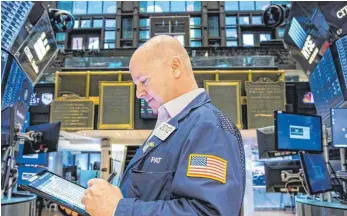  ?? FOTO: COURTNEY CROW/IMAGO IMAGES ?? Börsenhänd­ler an der New York Stock Exchange: Ein Split kann für optisch teure Aktien die Eintrittsk­arte in den weltweit am meisten beachteten Aktieninde­x, den Dow Jones Industrial Average, bedeuten.