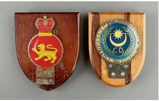  ??  ?? Two car badges mounted on wood plaques.