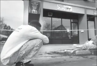  ??  ?? Above, a man is ovecome with emotion after learning about the fatal shooting. Right, a hazardous material handler cleans up blood in front of the barbershop.