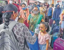  ?? PTI ?? A health worker does thermal screening and checks oxygen levels of passengers for COVID-19 test at Dadar railway station in Mumbai on Saturday.