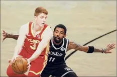  ?? Sarah Stier / Getty Images ?? Shenendeho­wa graduate Kevin Huerter controls the ball against Brooklyn’s Kyrie Irving during Atlanta’s 114-96 win.