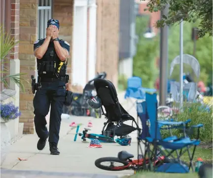  ?? BRIAN CASSELLA/CHICAGO TRIBUNE ?? A police officer walks amid items left by people who fled gunfire Monday in Highland Park.