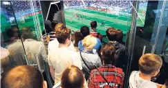  ?? AP ?? People watch the opening match between Russia and Saudi Arabia at the 2018 World Cup in a car dealership in Moscow, Russia, on Thursday.